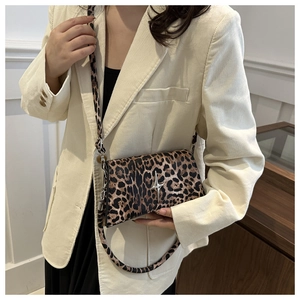 Dettaglio borsa a tracolla leopardata con logo a stella su blazer in velluto