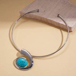 Macro detail of silver twisted collar with oval blue resin stone in retro style