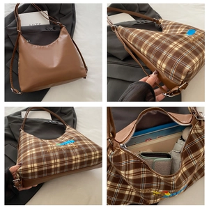 Detail view of large tote bag showing brown PU leather and plaid canvas with dog embroidery