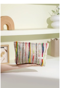 Vue détaillée de la grande trousse de toilette tissée à rayures arc-en-ciel avec étiquette