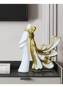 Détail de la sculpture de couple en céramique blanche et dorée avec une pose moderne