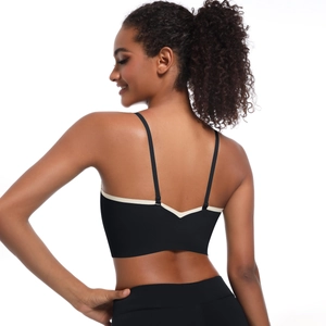 Detail of cross back straps and two-tone contrast piping on a black sports bra