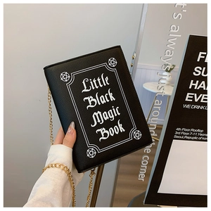 Detail of Little Black Magic Book print and golden chain on black gothic book bag