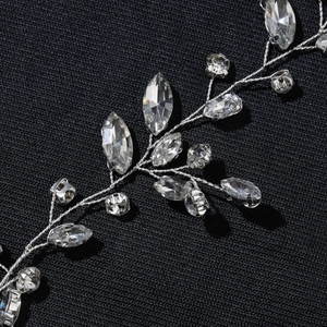 Macro shot of silver bridal hair vine with crystal rhinestones on dark fabric