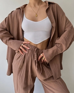 Close-up of brown linen button-down shirt paired with white ribbed knit vest top