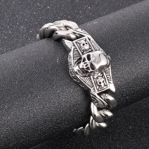 Vue macro du pendentif bouclier crâne et de la chaîne cubaine en acier vieilli