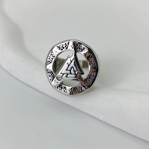 Macro detail showing the intricate Valknut symbol and Nordic runes on a steel ring