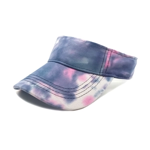 Detail of blue and purple tie-dye pattern on breathable sun visor hat with stitched brim