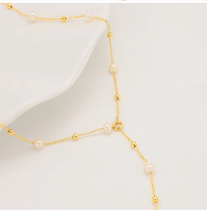 Detail shot of the 18k gold plated chain with delicate natural freshwater pearls