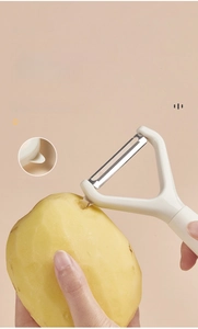Detail of white Y-shaped vegetable peeler showing the side bud remover for potatoes
