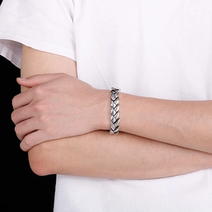 Close-up of a silver wheat-patterned men's steel dragon bone chain bracelet on wrist
