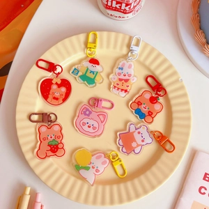 Close-up of cute acrylic animal charms with colorful lobster clasps on a tray