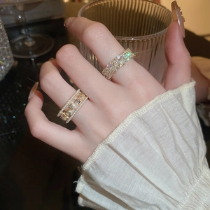 Close-up of gold hollow square zircon rings with pearls on hands for a luxury look