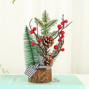 Mini Christmas tree with pine cones berries and wood base on a decorative book