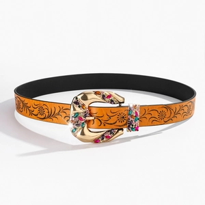 Detail of brown leather belt with floral engraving and gemstone-encrusted gold buckle