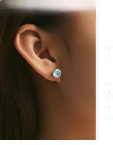 Close-up of s925 silver stud earring with blue round cut gemstone on ear