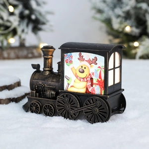 Vintage bronze Christmas train lantern with reindeer scene on artificial snow surface