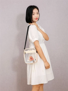 Detail of transparent PVC crossbody bag with cream leather trim and black nylon strap