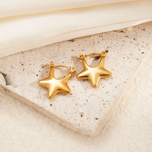 Detailed view of gold 18K stainless steel star earrings on elegant stone surface