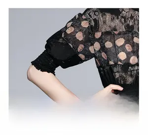 Close-up of elegant black lace dress sleeves with shirred cuffs and orange flower print