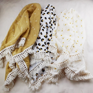 Detail of muslin baby blankets featuring floral and leopard prints with cotton tassels
