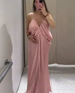 Detailed view of pink silk-texture slip dress with halter neck straps and draped fabric
