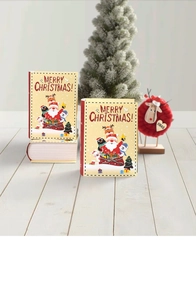 Detail of book-shaped Christmas gift boxes with Merry Christmas text on a festive background