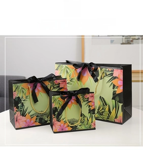 Detail of three floral gift bags with tropical hibiscus prints and black ribbon bows