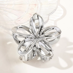 Detailed view of silver hollowed frangipani hair claw clip with smooth metallic finish