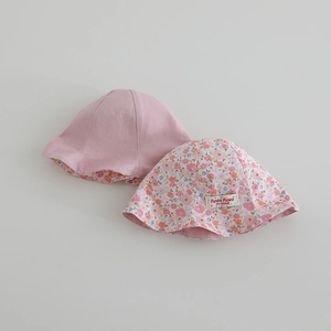 Détail de deux chapeaux de soleil pour bébé en coton rose doux et motifs floraux