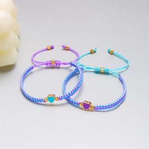 Dettaglio di bracciali intrecciati regolabili con ciondoli a cuore in smalto blu e viola