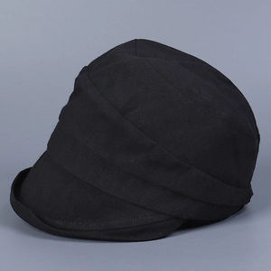 Detail view of the deep black cotton short brim cap with stylish fold texture