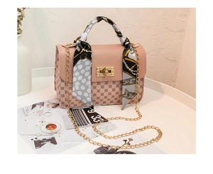 Détail du sac bandoulière en cuir PU rose et beige avec foulard et chaîne dorée