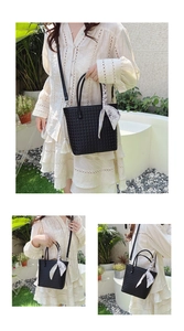 Detail of black woven tote bag with floral silk scarf and adjustable strap on a model