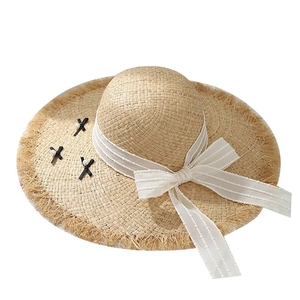 Beige raffia sun hat with wide fringe brim and elegant white tulle bow with pearls