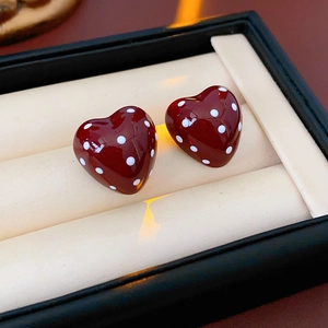Detail view of red polka dot heart earrings displayed in a premium jewelry box