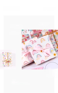 Detalle de papel de regalo con estampados de corazones, arcoíris y piedras de colores