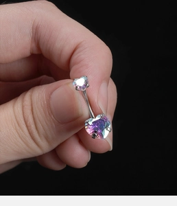 Close-up of heart-shaped AB colored cubic zirconia and silver titanium steel belly button ring