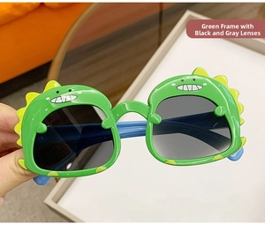 Close-up of green dinosaur sunglasses for kids with yellow fins and blue temples
