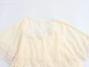 Dettaglio in primo piano del tessuto in chiffon beige con bordi in pizzo raffinato