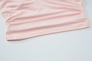 Close-up of pink fabric texture with elegant ruffled edges and soft pleated hem details