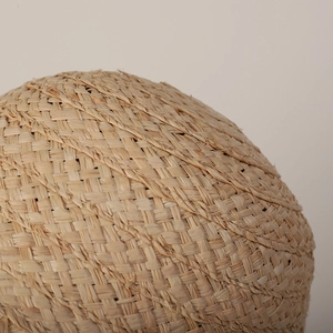 Close-up of hand-woven raffia straw hat showing natural plant fiber textures and intricate weave