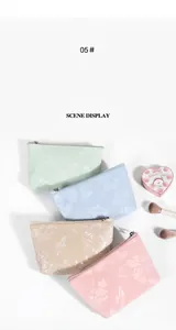 Detail of floral embossed PU leather makeup bags in multiple pastel colors with gold zippers