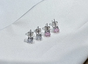 Detailed view of silver 925 studs with pink and clear 6mm zircons in four-prong settings