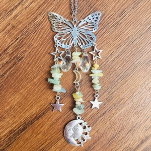 Detail of butterfly suncatcher with silver metal charms and green crystal stone beads