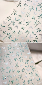 Detail of glitter green bamboo and white butterfly nail stickers with shimmer finish