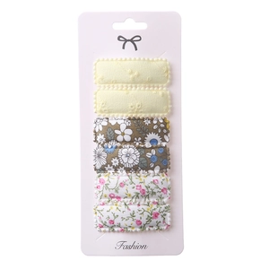 Detail of 6-piece floral embroidery fabric hair clips on a fashion display card