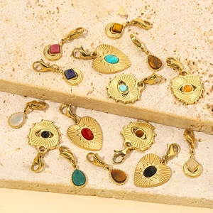 Vintage stainless steel pendants with heart and teardrop stones on stone surface