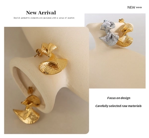 Macro detail of French vintage fan-shaped earrings with textured metallic finish