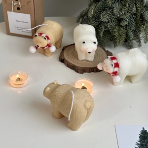 Polar bear candles in white and beige with red scarves in a craft gift box packaging